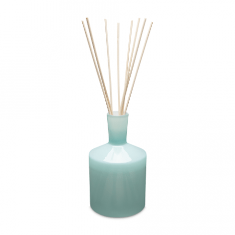 The Lafco - Marine 6oz Reed Diffuser, with its light turquoise glass bottle and filled with marine water and essential oils, features a narrow neck supporting multiple tall bamboo reeds against a plain white background.