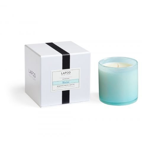 A light blue hand-blown glass Lafco Marine Classic 6.5 Candle sits beside its white box with a black stripe and Lafco Marine label, showcasing minimalistic, elegant packaging for this unlit marine bergamot candle.