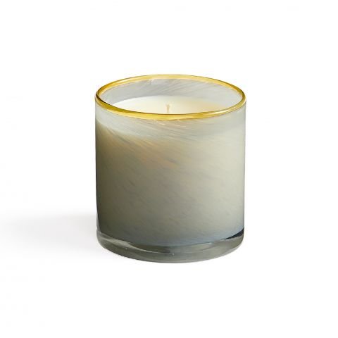 The Lafco - Sea & Dune Classic 6.5 Candle features a cream-colored wax in a glass holder with marbled patterns and a gold-accented rim, ready to emit its calming amber glow.