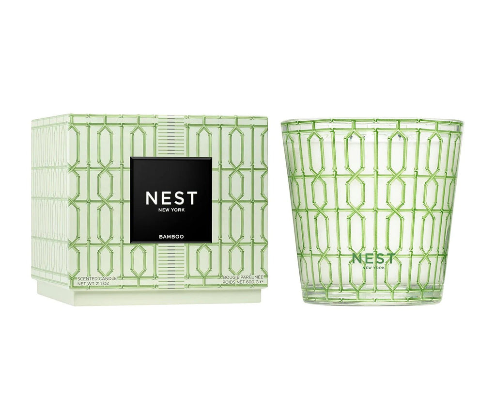 The Nest - Bamboo Decorative 3-Wick Candle by Nest features a fresh bamboo scent in a green geometric glass holder, displayed with its stylish matching box. Both showcase the brand and product name in black and white.