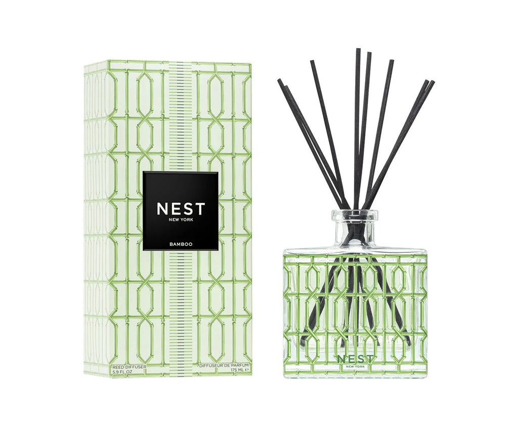 The Nest - Bamboo Decorative Reed Diffuser features black reeds and a green geometric-patterned box, both labeled Nest - Bamboo, suggesting a fresh floral fragrance.