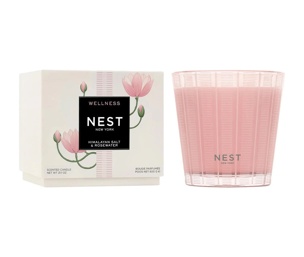 The Nest Himalayan Salt & Rosewater 3-Wick Candle features a pink rosewater scent in a ribbed reusable glass holder, shown next to its white box with pink lotus illustrations and “NEST NEW YORK - Himalayan Salt & Rosewater” label.