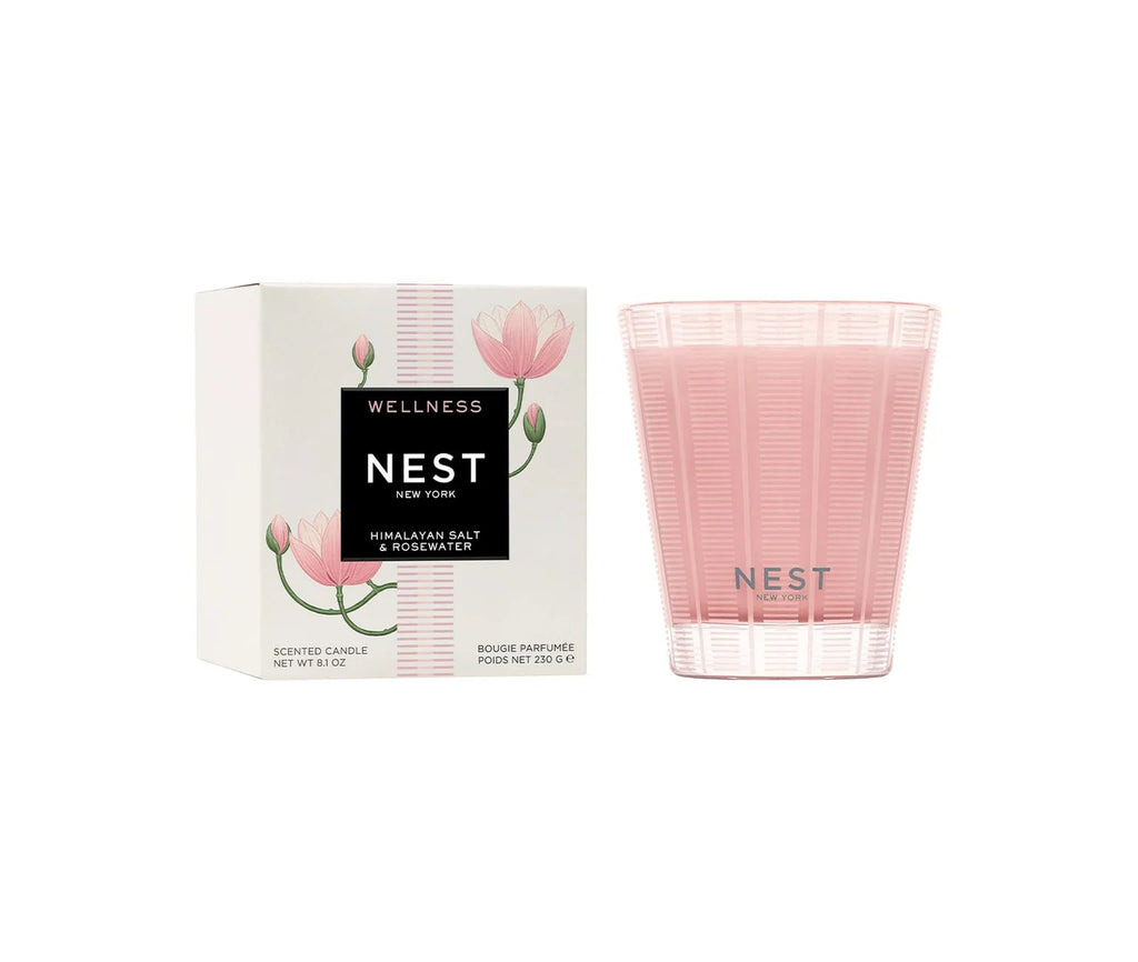 A Nest - Himalayan Salt & Rosewater Classic Candle sits beside its matching box, both featuring fresh pink floral designs and Nest branding.