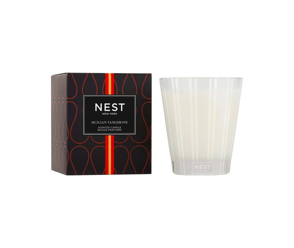 The Nest - Sicilian Tangerine Classic Candle by Nest comes in a white glass holder next to its black box with red and gold details, featuring the Nest logo and premium wax for a luxurious scent.