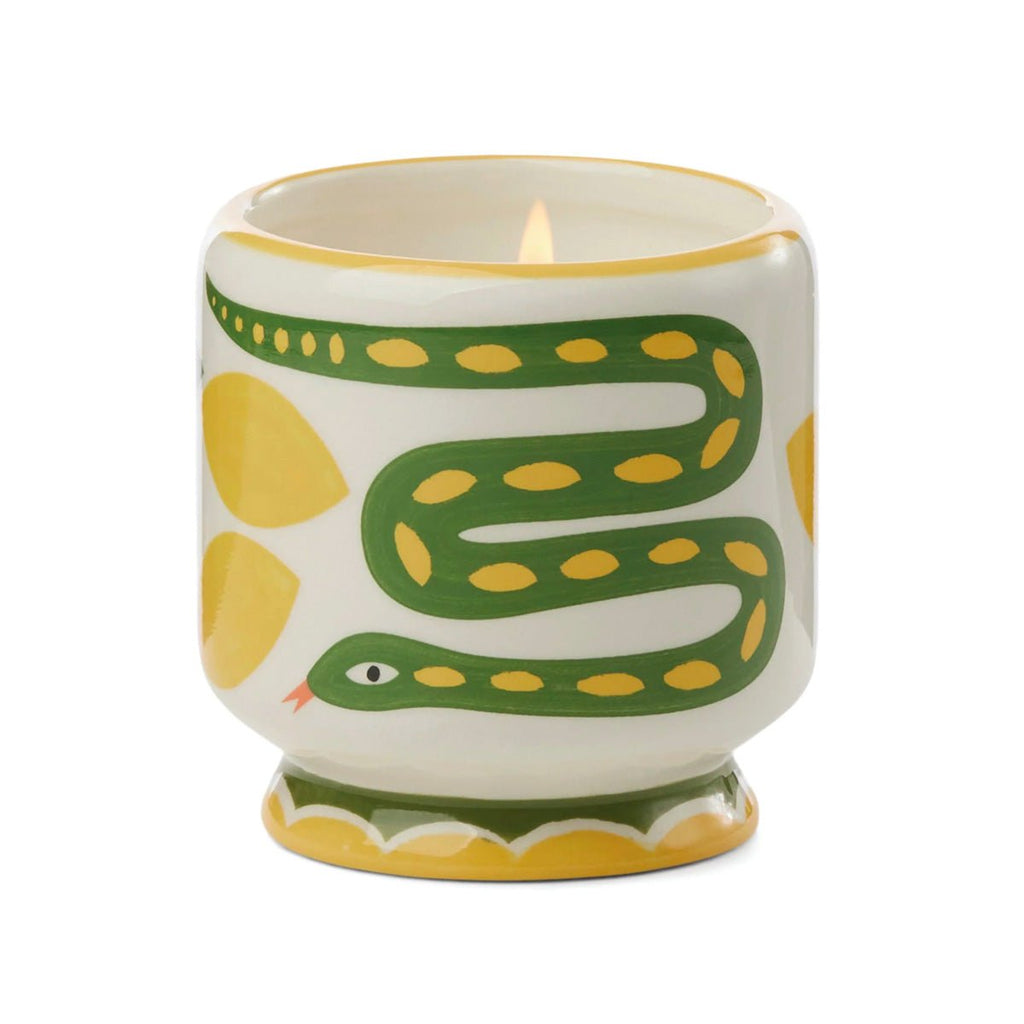 The Paddywax - A Dopo Wild Lemongrass Handpainted 8oz Candle is a ceramic candle holder featuring a soy wax candle. It displays a striking design with a green snake and yellow spots, intertwined with vibrant yellow leaf patterns, and the rims are elegantly accented in yellow.