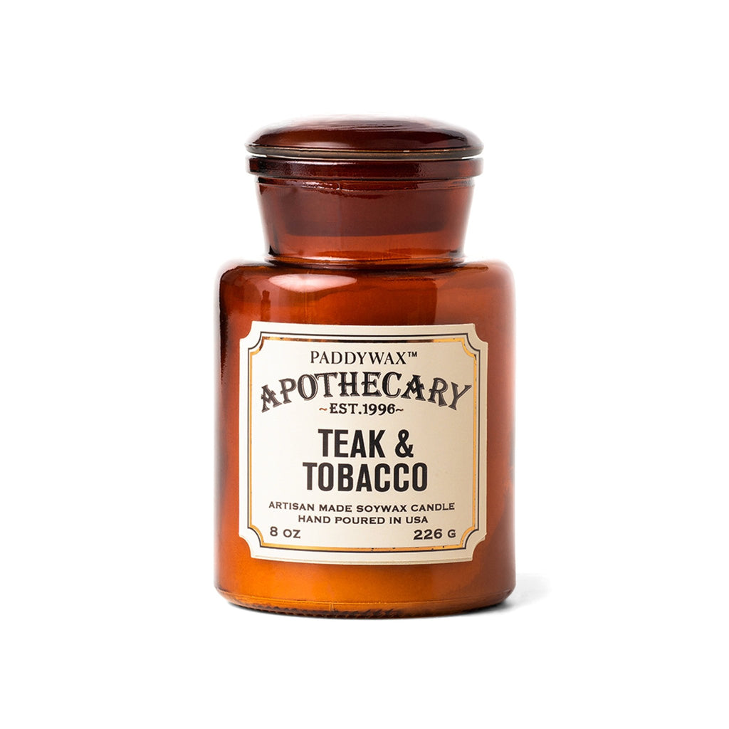 The Paddywax Apothecary Teak & Tobacco candle, hand-poured in the USA, is an 8 oz artisan-made soy wax candle housed in a vintage-inspired amber glass jar.