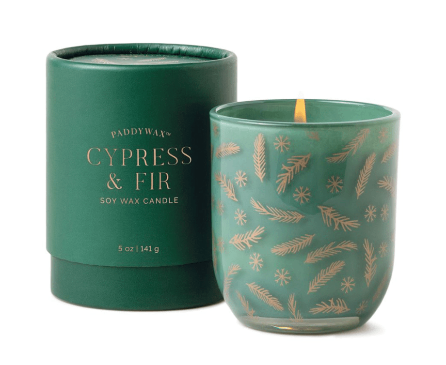 The Paddywax - Cypress & Fir candle in a green opaque glass flickers warmly, spreading holiday cheer with its gold cypress and frosted fir designs, complemented by matching green cylindrical packaging.