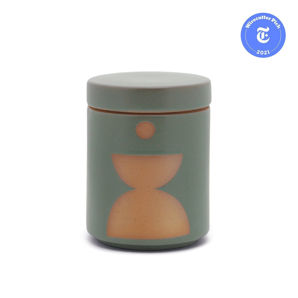 The Paddywax - Form candle is a 12oz matte green ceramic jar with a lid, adorned with a minimalistic abstract tan design, perfect as an elegant candle planter. A round emblem states Wirecutter Pick 2021.