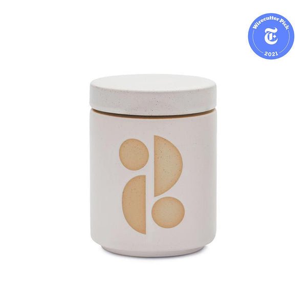 The Paddywax Form 12oz Candle in beige ceramic features a geometric design, doubling as a chic planter. The matching lid complements its look, and a blue Wirecutter Pick 2021 sticker adorns the top right corner.