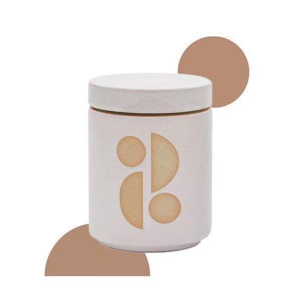 The Paddywax - Form Tobacco Flower 12oz Candle in a white ceramic jar features a minimalist design with abstract beige shapes and two tan circular accents, making it a stylish choice for garden-inspired fragrances or as an elegant candle planter.