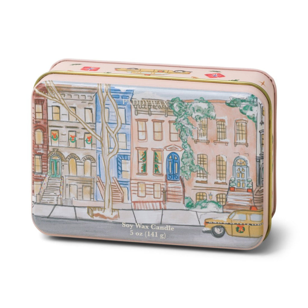 Paddywaxs Holiday Candle Tin features a colorful urban row house and yellow taxi design. One side reads Soy Wax Candle 5 oz (141 g). Infused with tangerine and clove, it evokes the warm ambiance of a holiday candle.