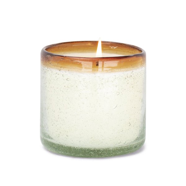 The Paddywax - La Playa Orange Blossom 9oz Candle, crafted by Mexican artisans from recycled bubble glass, features a textured holder with a light green to amber gradient, casting a warm glow and embracing sustainable beauty.