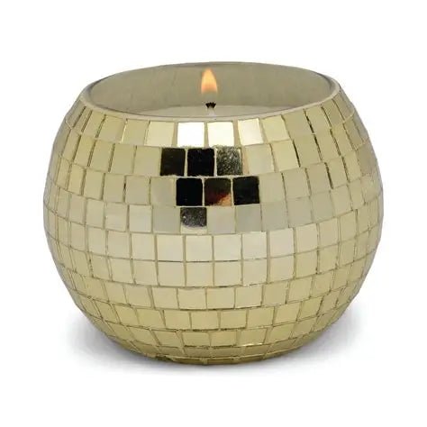 The Paddywax Magique 10 oz Gold Disco Ball candle features a visible flame and comes in a round gold mosaic glass holder with a reflective tiled surface. Scent: Copal & Myrrh.