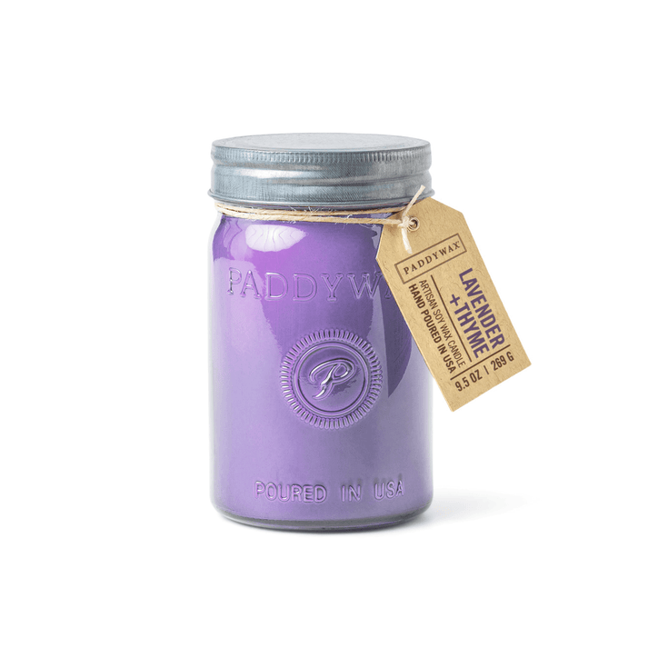 The Paddywax Relish Lavender + Thyme 9.5oz candle features lavender-colored wax in a glass jar with a metal lid, embossed with “Paddywax” and “Poured in USA,” plus a brown tag labeled Lavender + Thyme by Paddywax.