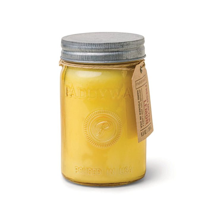 The Paddywax Relish Fresh Meyer + Lemon 9.5oz Candle comes in a yellow mason jar with a metal lid and brown paper tag; the reusable jar features embossed "Paddywax" and "Poured in USA" text.