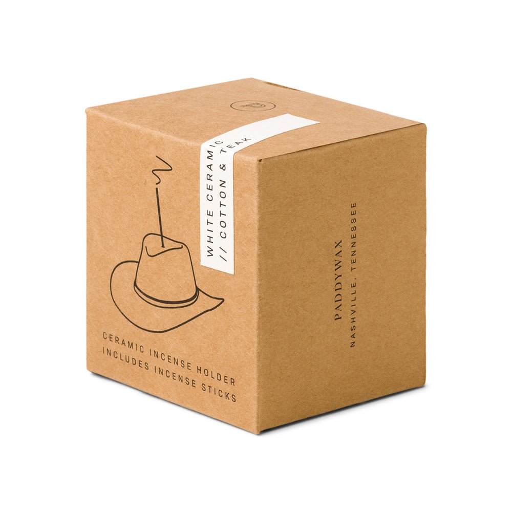 A brown Paddywax box labeled White Ceramic // Cotton & Teak features a cowboy hat-shaped ceramic incense holder drawing and mentions included incense sticks. Branding is from Nashville, Tennessee.