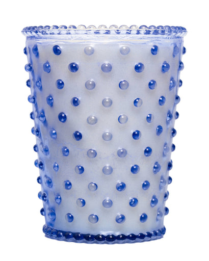 The Simpatico Lavender Hobnail Candle features a cylindrical blue glass container with a raised dot pattern for a textured look. Its perfect for lavender-infused soy wax candles, offering a translucent appearance against a white background.