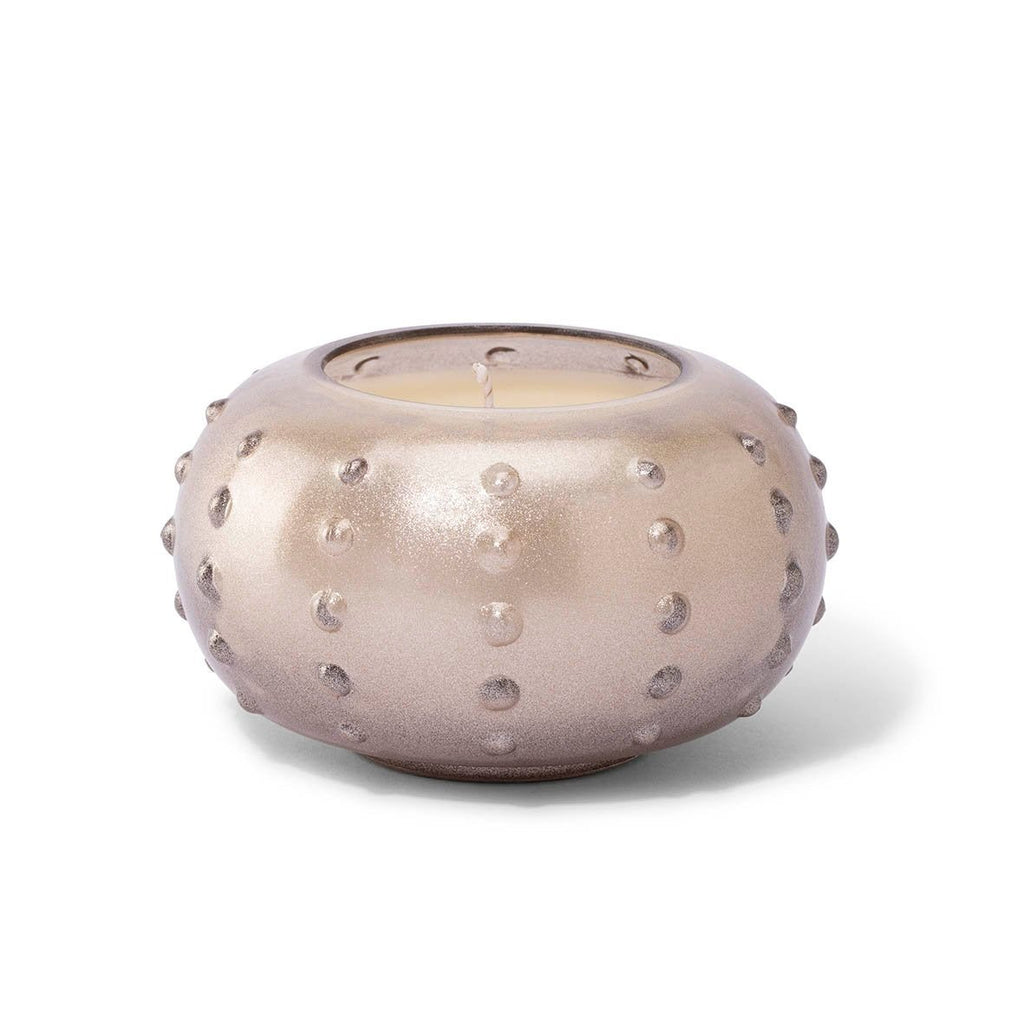 The Skeem Champagne Candlescape 10 oz Candle in Yuzu Pine features a round holder with a textured, knobby metallic surface and subtle iridescent sheen.