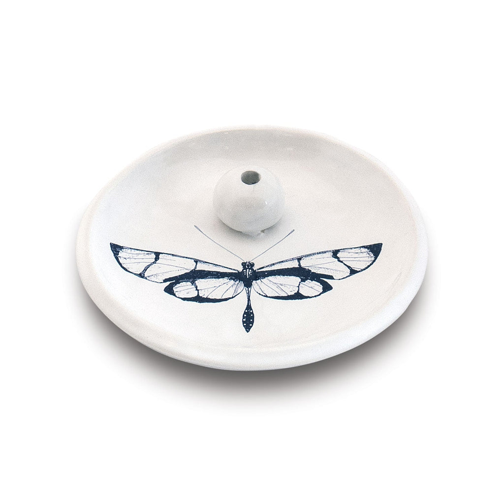 The Skeem Citronella Incense Holder is a white ceramic outdoor burner with a small central holder and detailed black butterfly illustration, offering handmade charm and bug protection for your space.