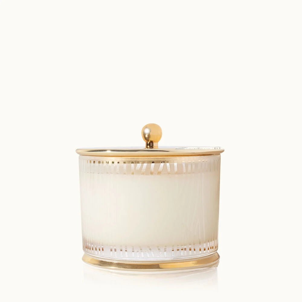 The Thymes Frasier Fir Gilded Frosted Wood Grain Candle features a white wax in a frosted glass jar with gold stripes and a round-knob gold lid, showcased against a plain white background.