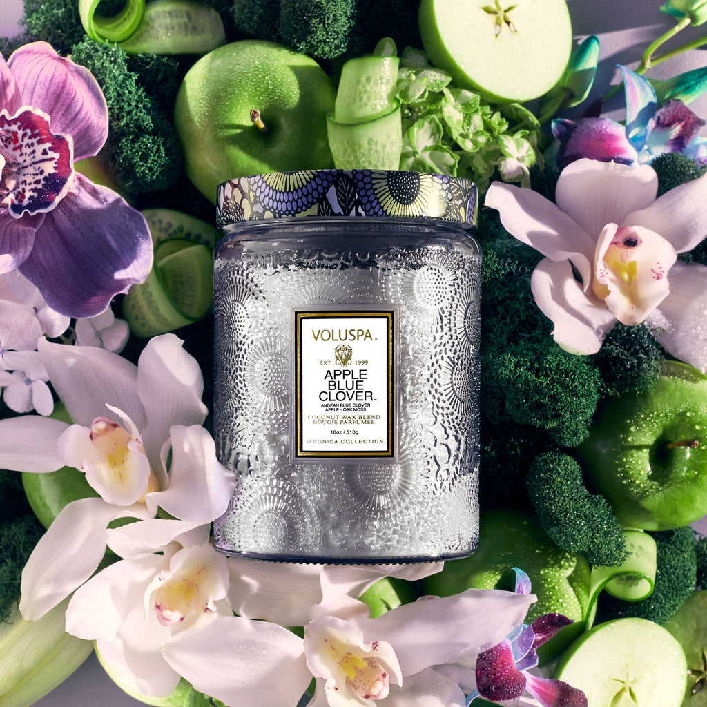 The Voluspa Apple Blue Clover Large Jar 18oz Candle blends coconut wax with green apples, broccoli, and orchids. Its intricate jar design complements this vibrant mix, enhancing its impressive fragrance throw.