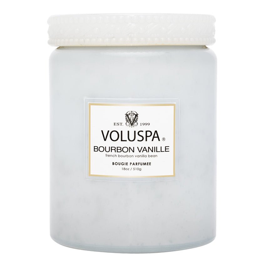 The Voluspa Bourbon Vanille Jar 18oz Candle, featuring a French bourbon vanilla bean label, offers a decadent gourmand fragrance. This elegant candle comes in a white frosted glass jar with a textured lid and includes an 18 oz coconut wax blend.