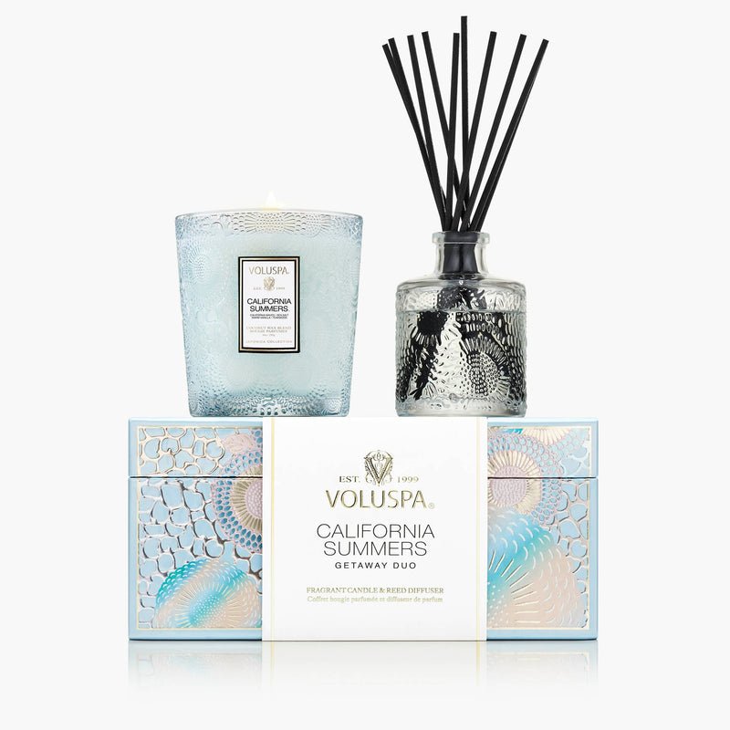 The Voluspa - California Summers Getaway Duo Gift Set includes a blue Coconut Wax Candle and a clear Reed Diffuser with black reeds, both beautifully presented in a decorative pastel box.