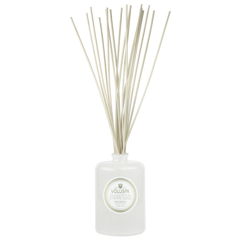 The Voluspa Eucalyptus & White Sage Reed Diffuser features a minimalistic design with a round scent label. Thin reeds emerge from its top, filling your space with calming notes of eucalyptus and white sage.