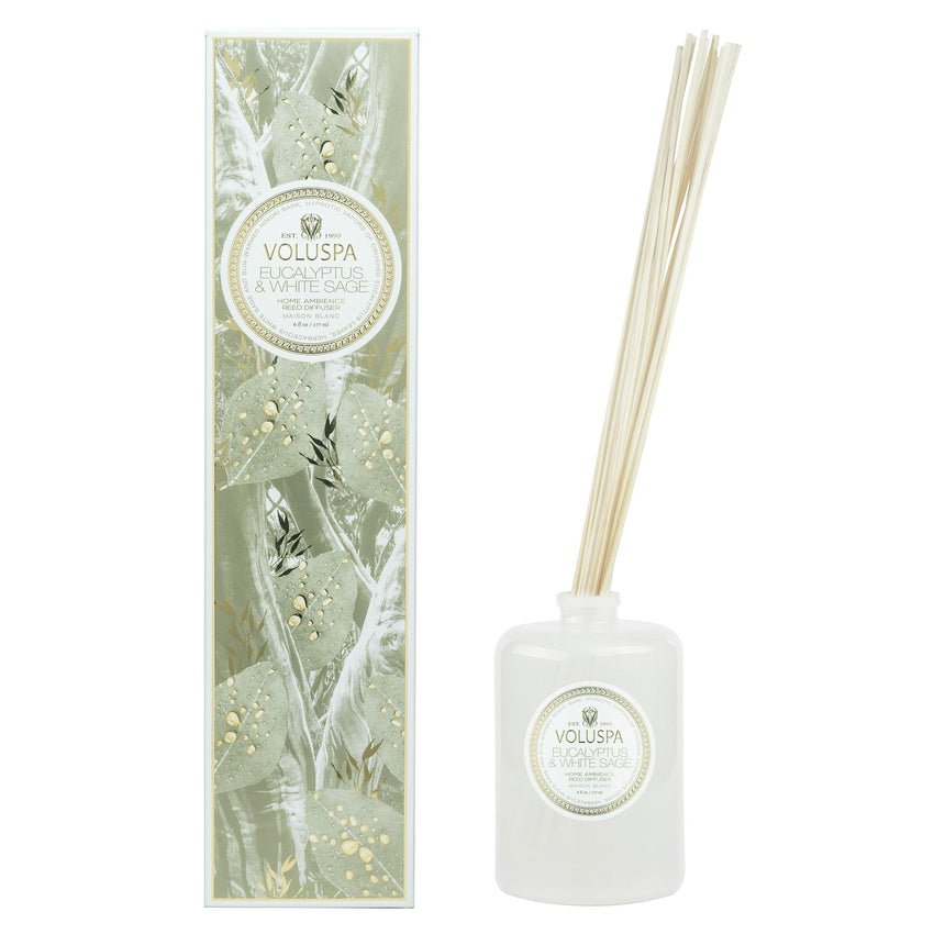 The Voluspa - Eucalyptus & White Sage 172ml Reed Diffuser features a white bottle with a round label and slender reeds. Its tall rectangular box is adorned with leaf designs and matching branding for a refreshing look.