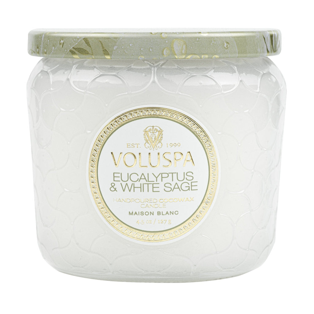 The Voluspa Eucalyptus & White Sage Petite 4.5oz Jar Candle features coconut wax hand-poured into a textured glass jar with a matching lid. Its Maison Blanc label and elegant embossed design enhance its presentation.