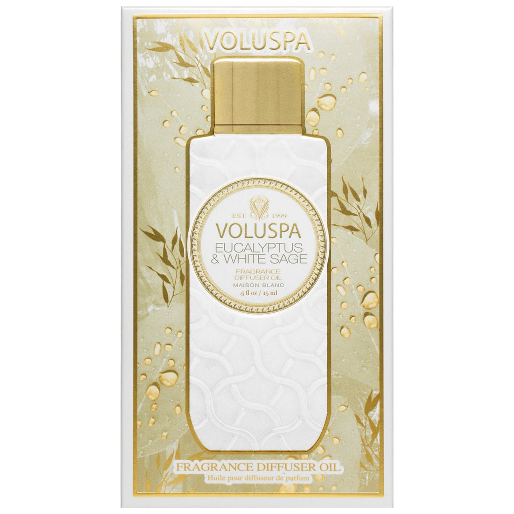 A rectangular box with golden accents hosts the Voluspa Eucalyptus & White Sage Ultrasonic Diffuser Fragrance Oil. The embossed label, featuring eucalyptus leaf illustrations, is complemented by a gold cap, enhancing its elegant design.