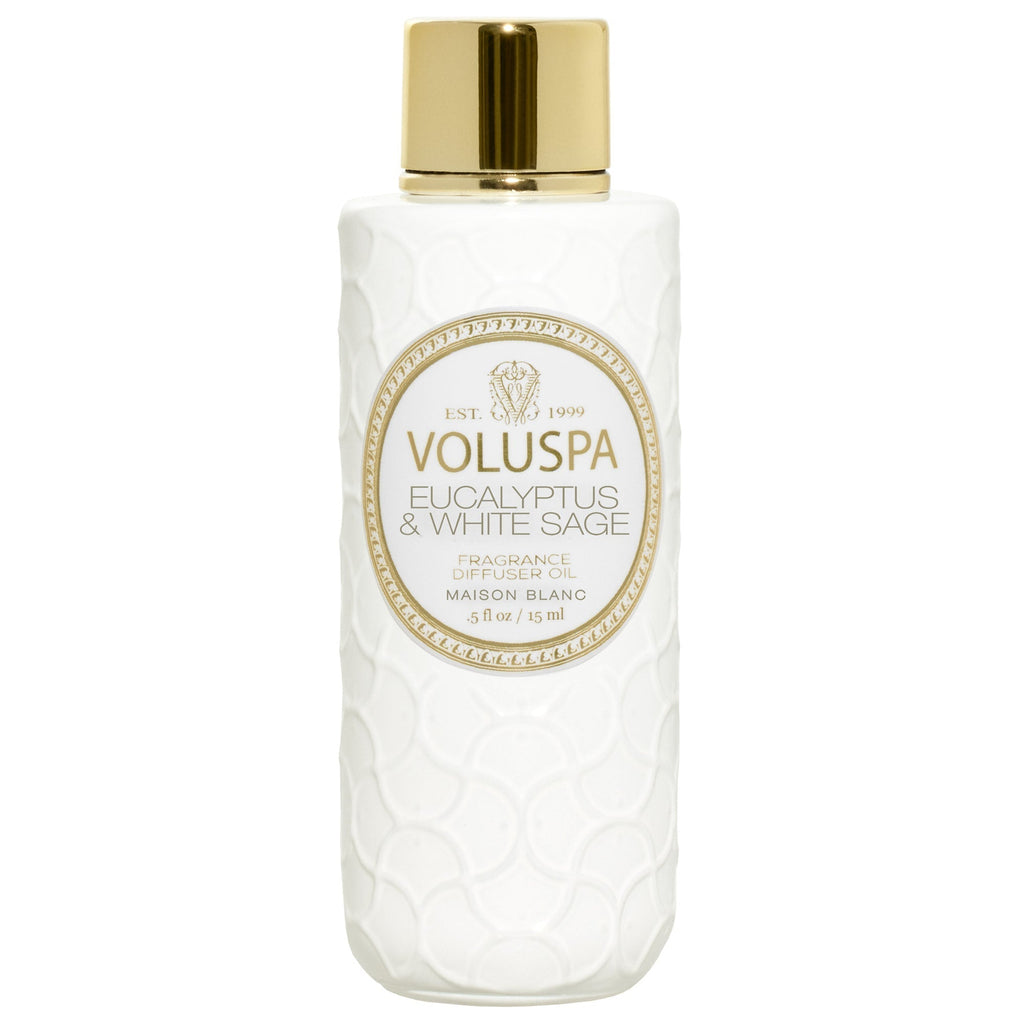 The Voluspa Eucalyptus & White Sage Ultrasonic Diffuser Fragrance Oil features a white bottle with a gold cap and an embossed texture, beautifully highlighting the label Voluspa - Eucalyptus & White Sage. This 5 fl oz Maison Blanc item exudes charm and sophistication.