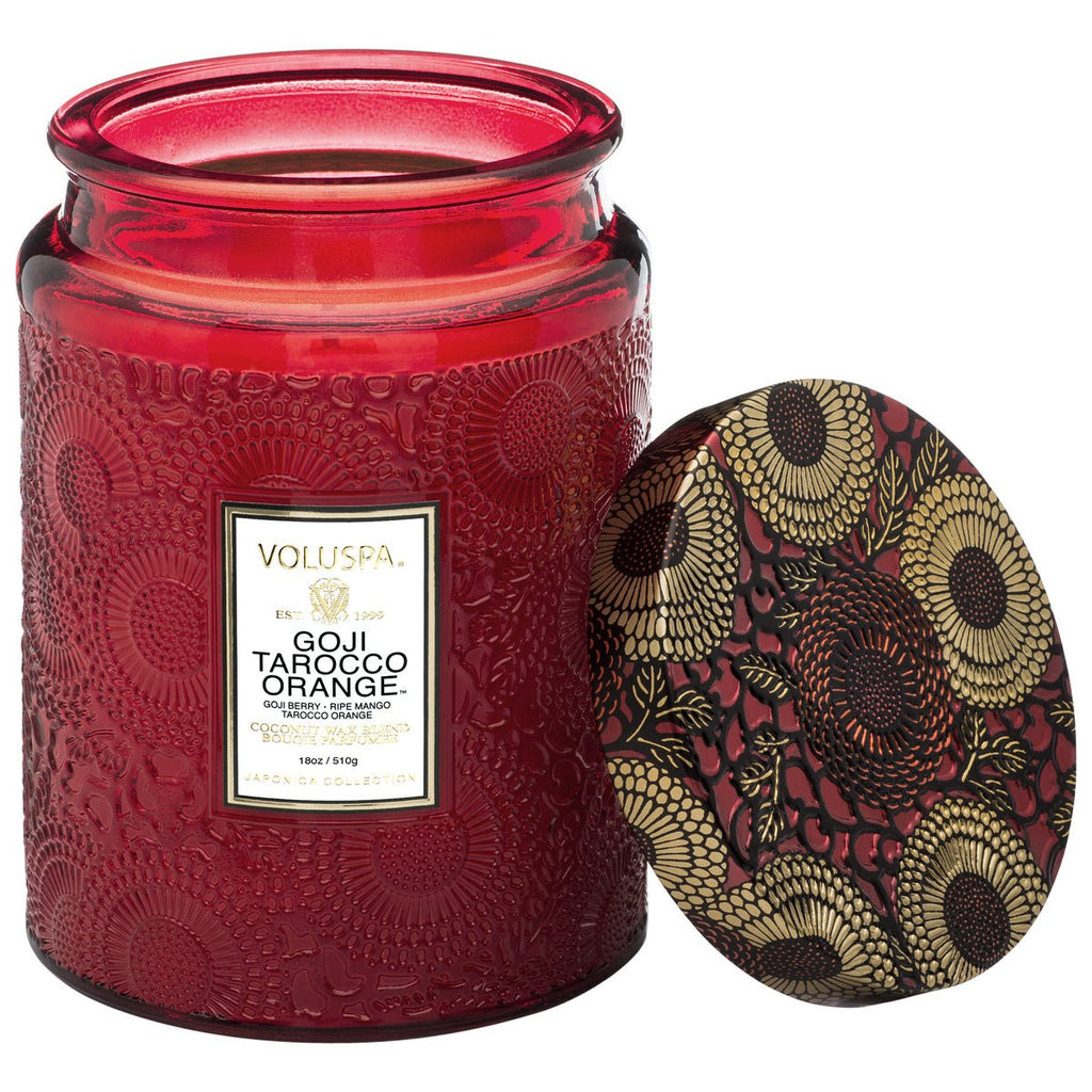 The Voluspa Goji Tarocco Orange Large Jar Candle features a decorative red embossed glass and a gold-red floral lid, revealing enticing goji berry and mango scents.