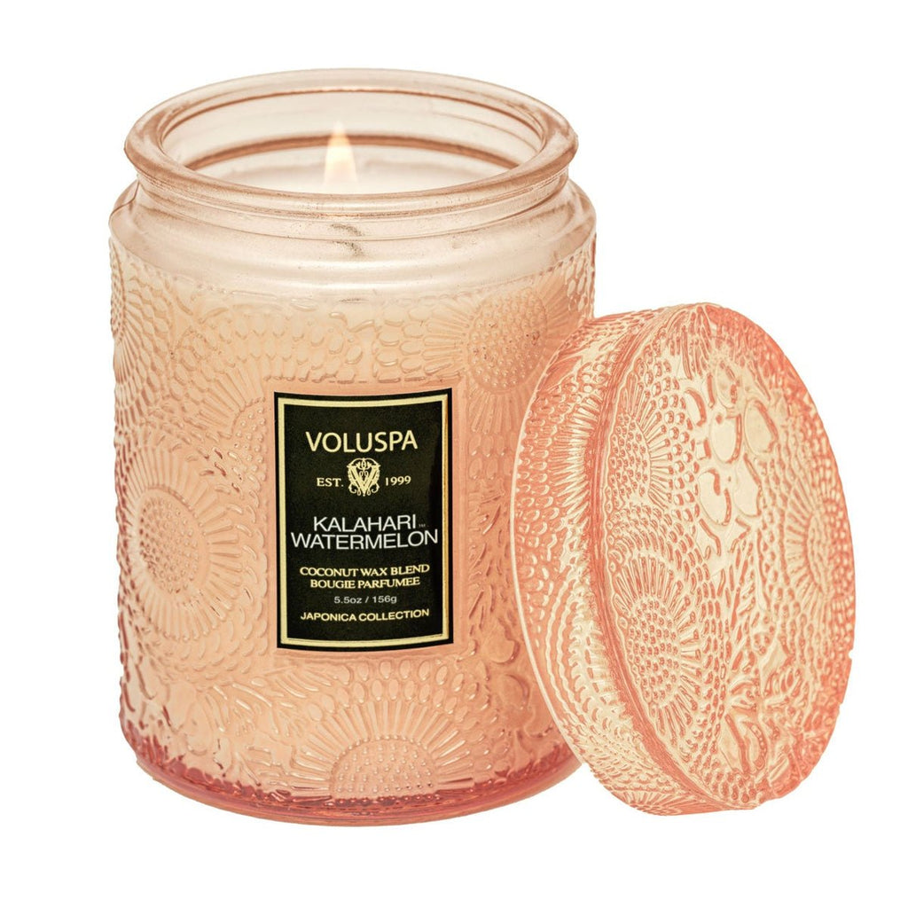 An intricately patterned pink glass jar candle with a matching lid from Voluspas Japonica Collection, labeled Kalahari Watermelon. Infused with a crisp watermelon fragrance, it features luxurious coconut wax and is 5.5oz in size.