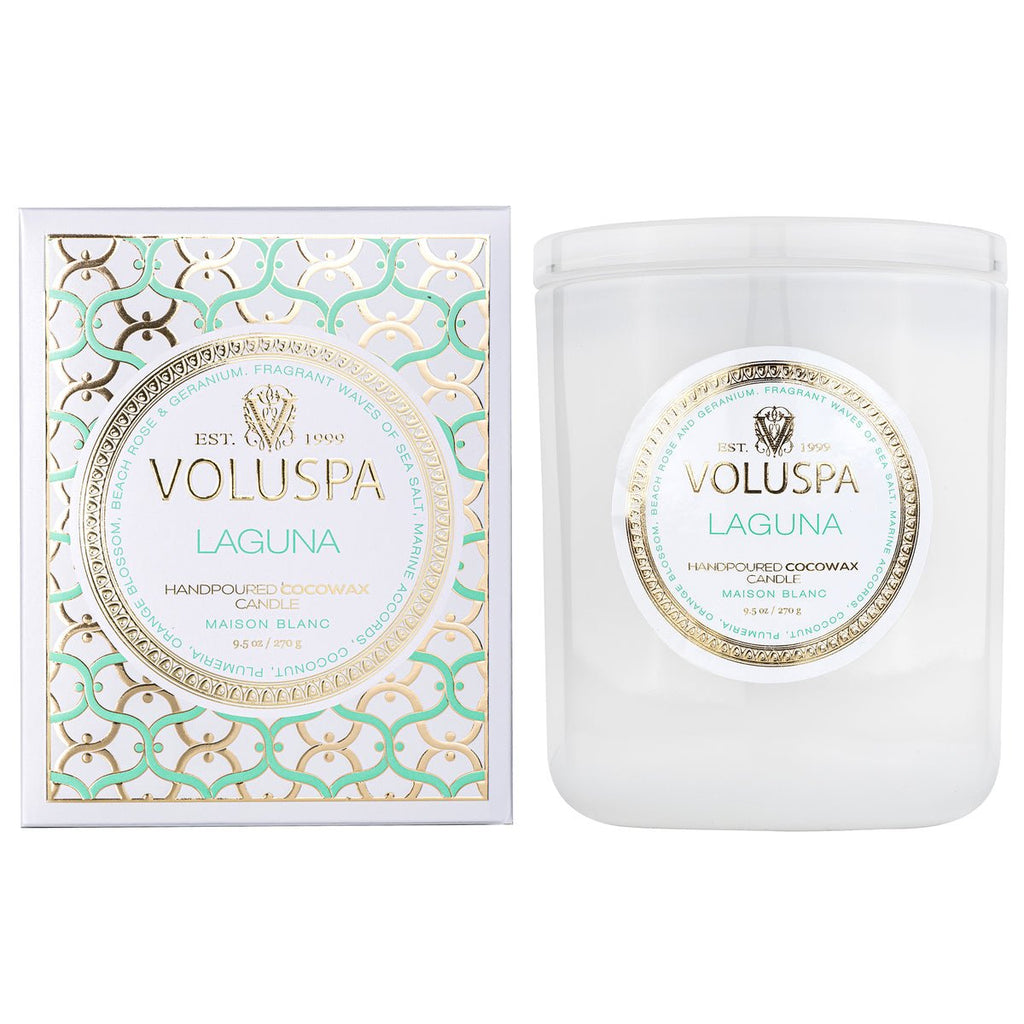 A Voluspa - Laguna Classic Candle 9.5oz beautifully accompanies its box, featuring a gold, white, and light blue design that enhances the luxurious coconut wax blend. The candles fragrance throw is outstanding, with elegant branding on the white jar and matching label.