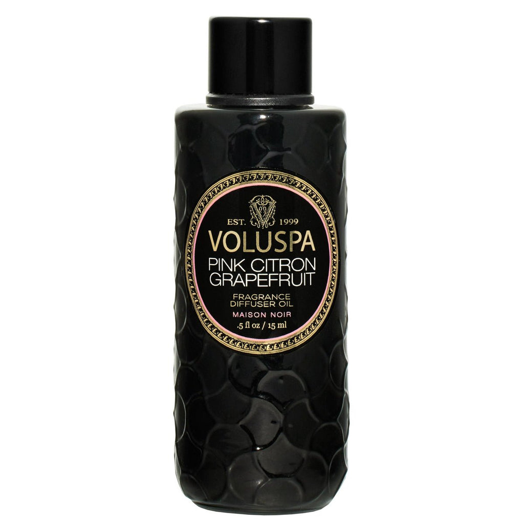 The Voluspa Pink Citron Grapefruit Ultrasonic Diffuser Oil comes in a black textured bottle with an ornate label featuring gold and pink details. This 4.5-ounce treasure fills any room with the vibrant essence of essential oils, creating a fragrant haven.