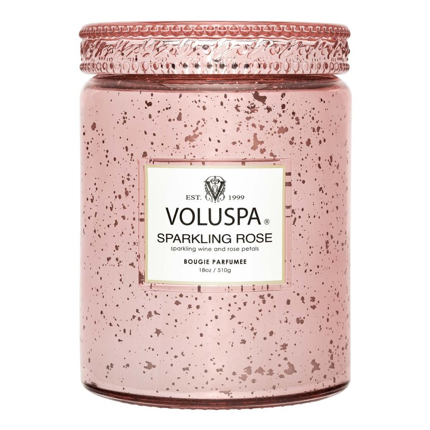 The Voluspa Sparkling Rose Large Jar Candle features a pink speckled glass design with a metal lid, exuding floral notes of sparkling wine and rose petals. This Bougie Parfumée is made with coconut wax and weighs 18oz / 510g.