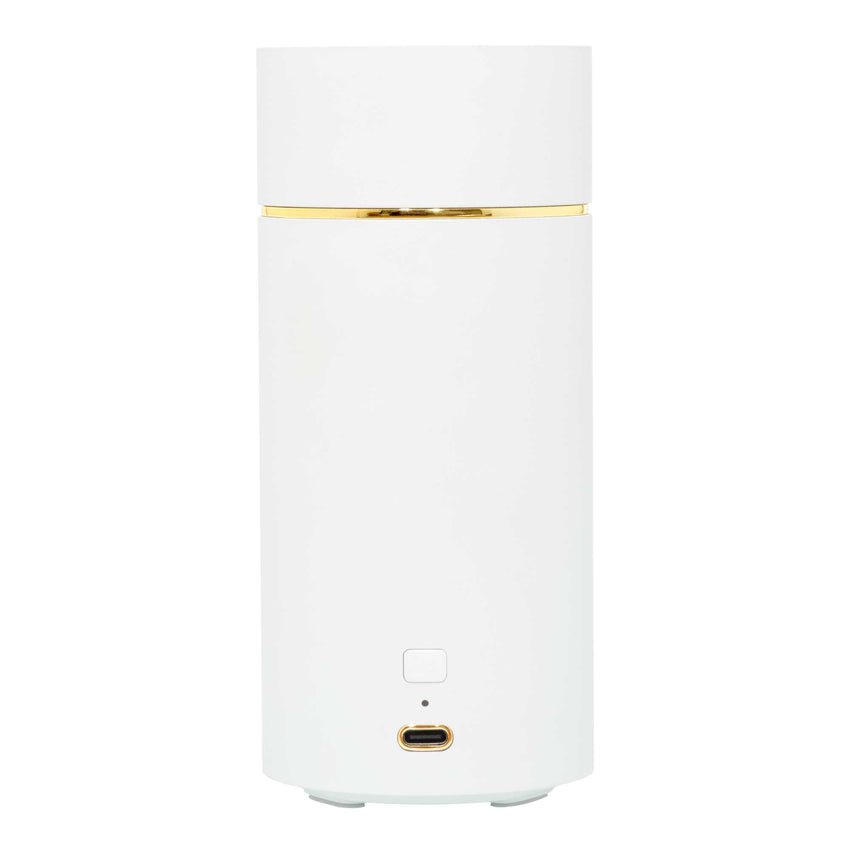 The Voluspa White Ultrasonic Fragrance Oil Diffuser is a tall, cylindrical cordless device with a gold accent near the top. It has a USB-C port, a small indicator light at the front bottom, and features a smooth, minimalistic surface.