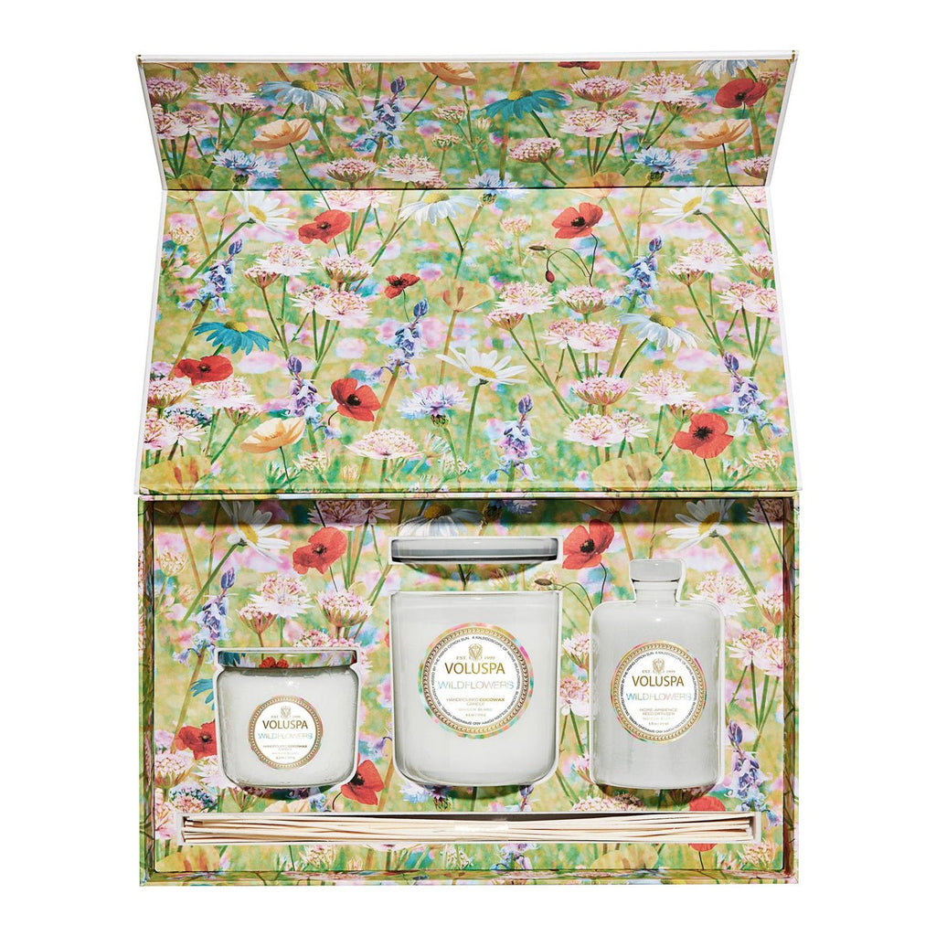 The Voluspa - Wildflowers Superbloom Gift Set features three scented candles and diffuser sticks in a colorful box adorned with vibrant native wildflowers, infused with a refreshing soft citrus aroma.