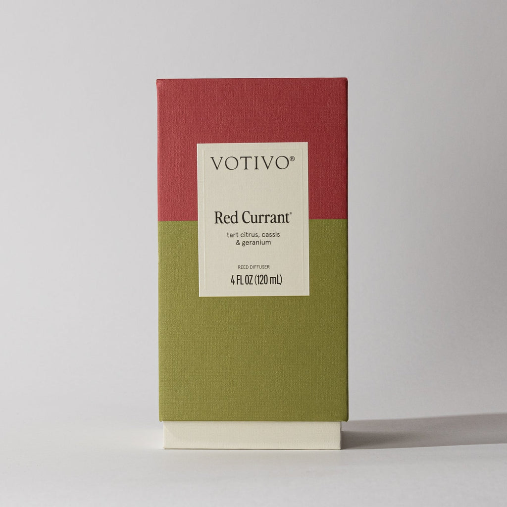 The Votivo - Red Currant Reed Diffuser comes in a red and olive green box featuring notes of cassis and geranium, blending earthy greens with tart citrus. The package contains 4 fl oz (120 ml).