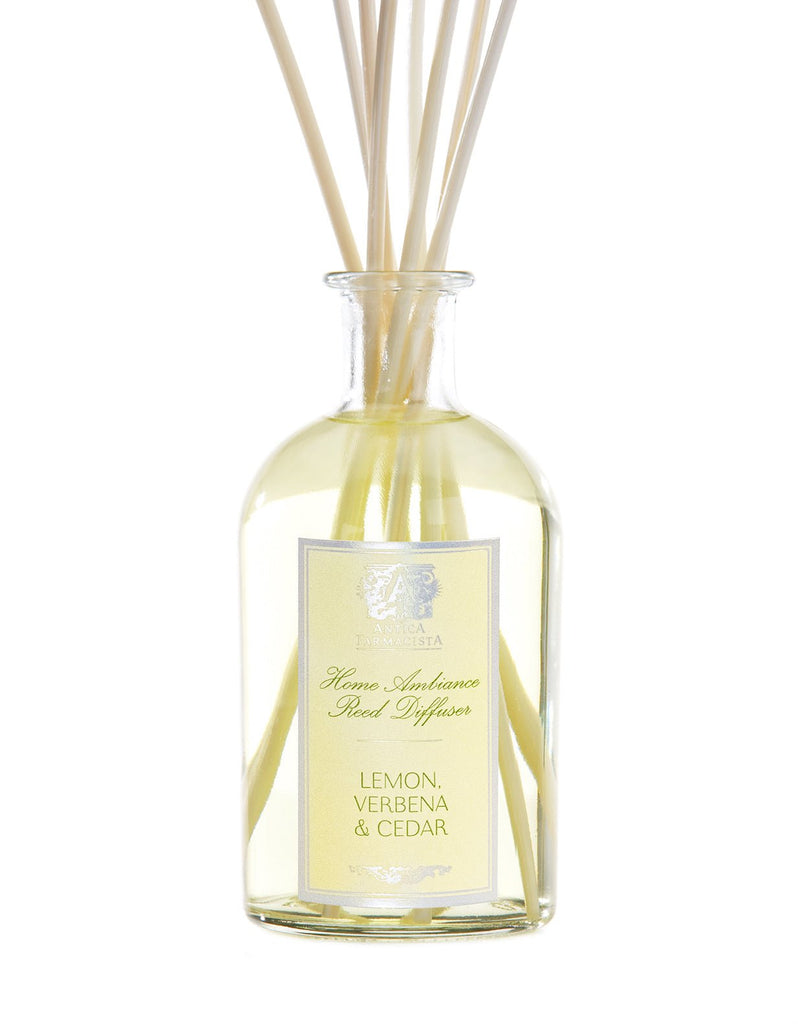 The Antica Farmacista - Lemon Verbena & Cedar 250ml Reed Diffuser features light yellow liquid in a clear glass bottle with reeds, filling your space with a vibrant citrus scent.