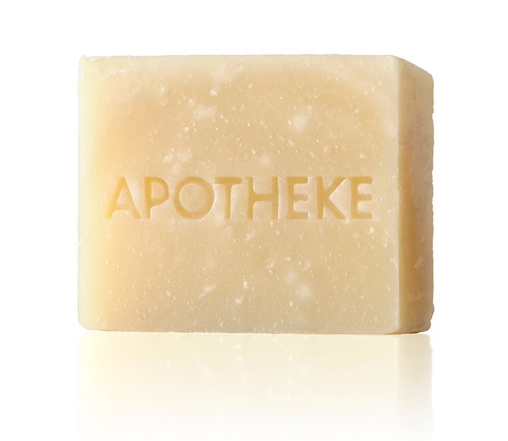 The Apotheke Sea Salt Grapefruit Bar Soap, embossed with APOTHEKE, is plant-based and offers a refreshing citrus aroma. Its invigorating scent stands out against a plain white background.