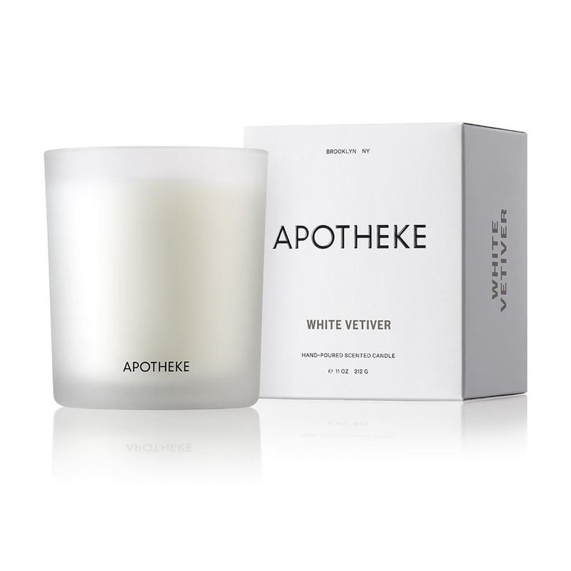 An Apotheke - White Vetiver Classic Candle 10.5oz, in a white glass labeled APOTHEKE, sits beside a matching box with White Vetiver text. This luxury candles minimalist design features elegant black text on a pristine white background, exuding timeless sophistication.