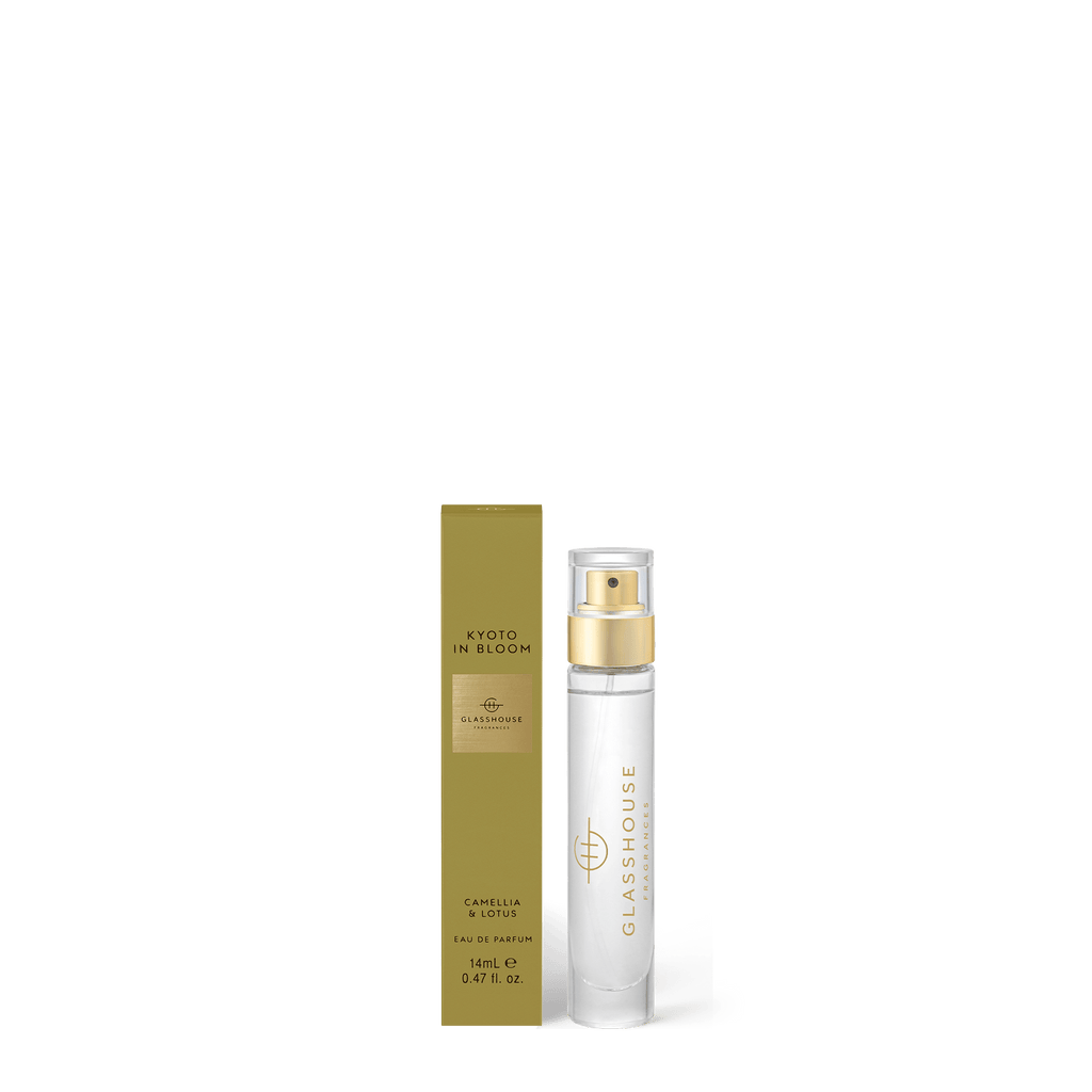 A 14ml Glasshouse Fragrances Eau de Parfum, Kyoto In Bloom, sits beside its gold box. This scent blends camellia and lotus for a captivating white floral fragrance.