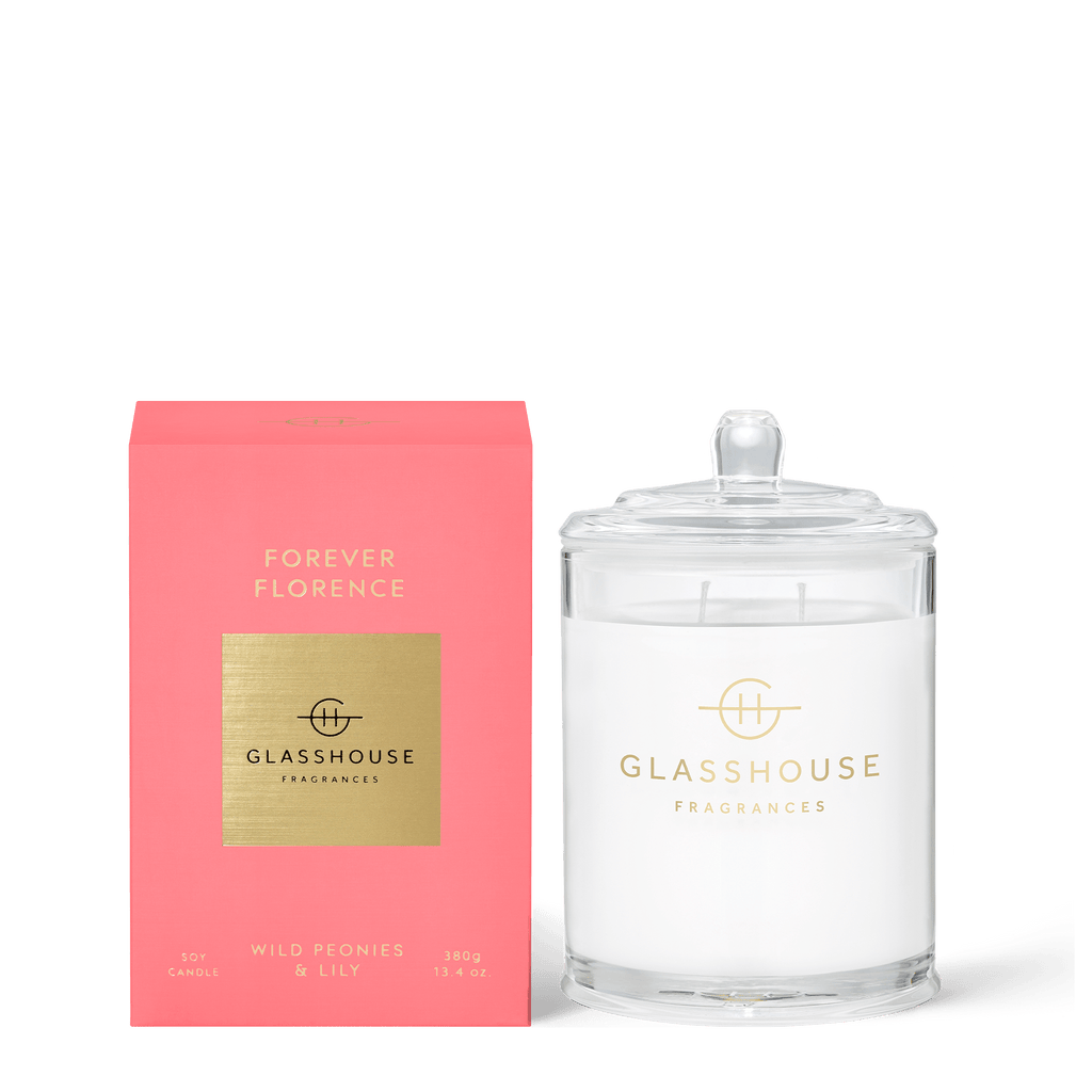 The Glasshouse Fragrances Forever Florence 13.4oz candle fills the air with enchanting wild peonies and lily aromas. It comes in a clear glass jar with a lid, beautifully paired with its elegant pink box featuring gold accents.