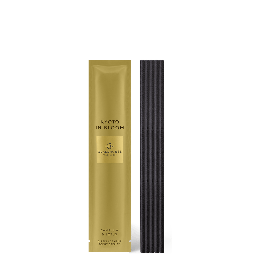 A rectangular gold box labeled Kyoto in Bloom stands next to sleek black incense sticks, elegantly showcasing Glasshouse Fragrances Replacement Scent Stems in the Camellia & Lotus fragrance, complete with five stems for a harmonious atmosphere.