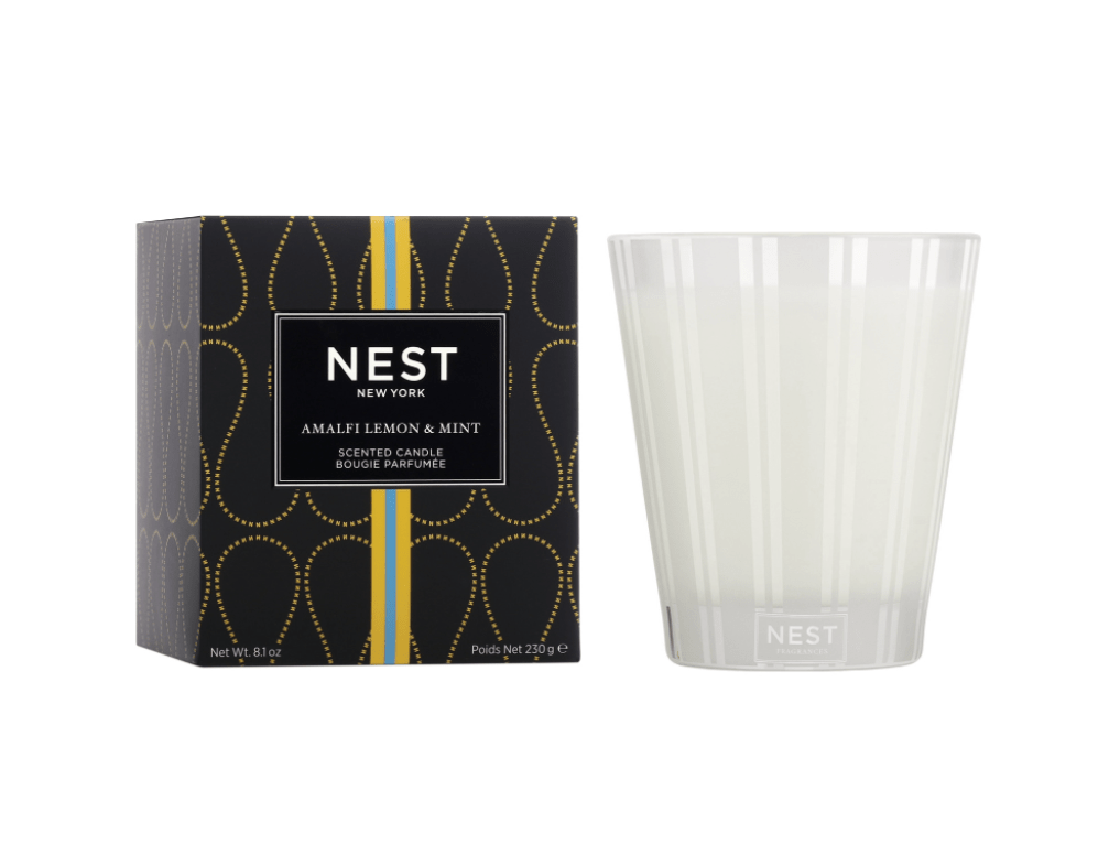 A frosted glass Nest candle sits beside its black and gold box labeled "Nest - Amalfi Lemon & Mint Classic Candle.
