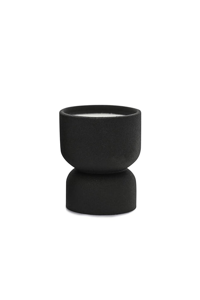 The Paddywax Form Palo Santo Suede 6oz Candle features a chic, black double-stacked ceramic vessel with a matte finish. Its top is wider for liquids, while the bottom acts as a smooth stand. Its sleek silhouette stands elegantly on a white background, making it ideal as a candle planter.