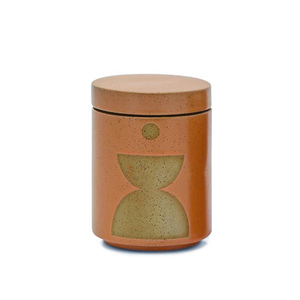 The Paddywax Form Wild Fig + Vetiver 12oz Candle features a cylindrical ceramic jar with a fitted lid, earthy orange color, and an abstract muted green geometric design on the front. Background: plain white.